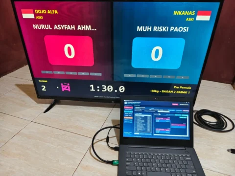Aplikasi manajer turnamen Karate digunakan pada laptop operator dengan public scoreboard Kumite