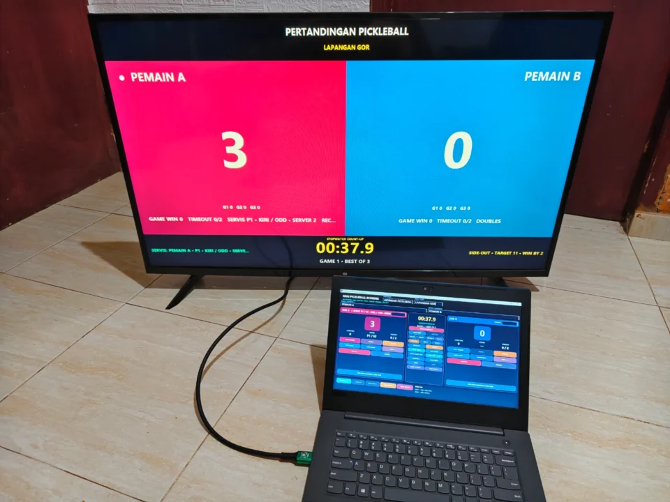 Papan skor Pickleball digital digunakan operator dengan public scoreboard pada TV