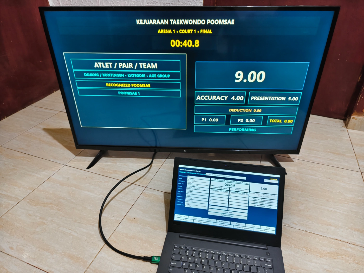 Papan skor Taekwondo Poomsae digital digunakan operator dengan public scoreboard pada TV