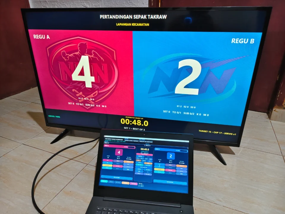 Papan skor Sepak Takraw digital digunakan operator dengan tampilan TV atau monitor publik