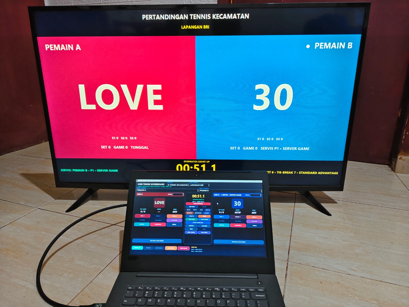 Papan skor tenis lapangan digital menampilkan skor Love dan 30 pada layar pertandingan